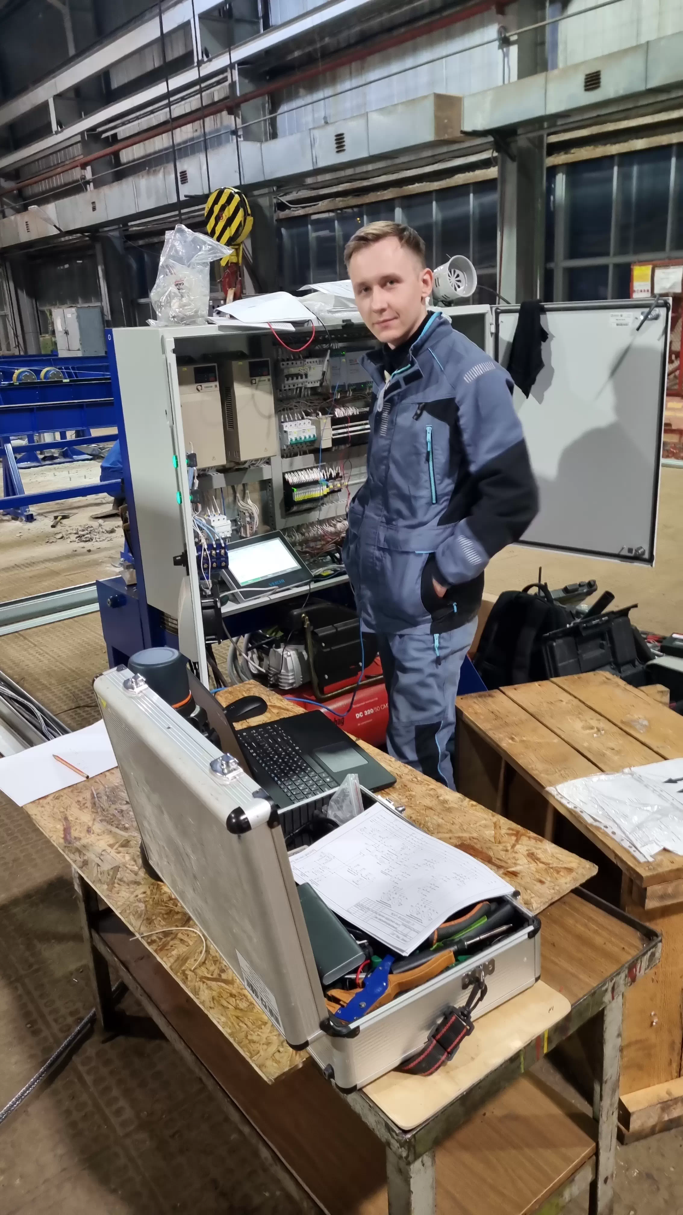 Специалист на промышленном объекте у шкафа управления